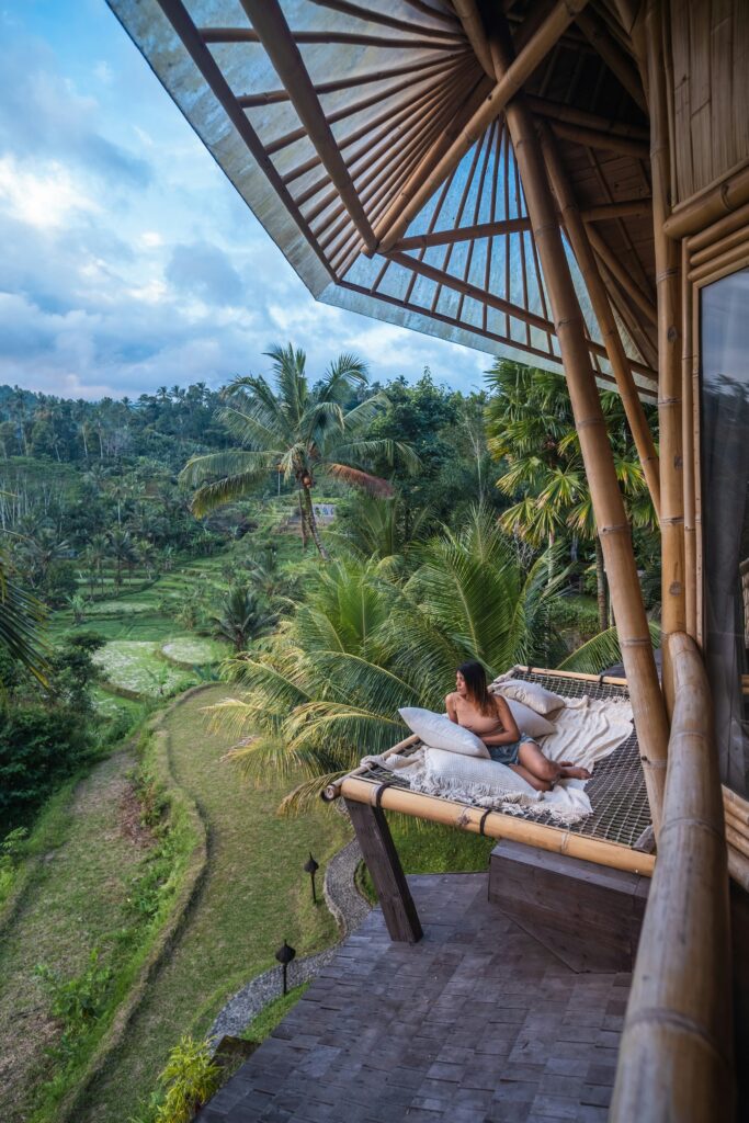 Villa met dame in de hangmat. Op de achtergrond rijstvelden Bali.