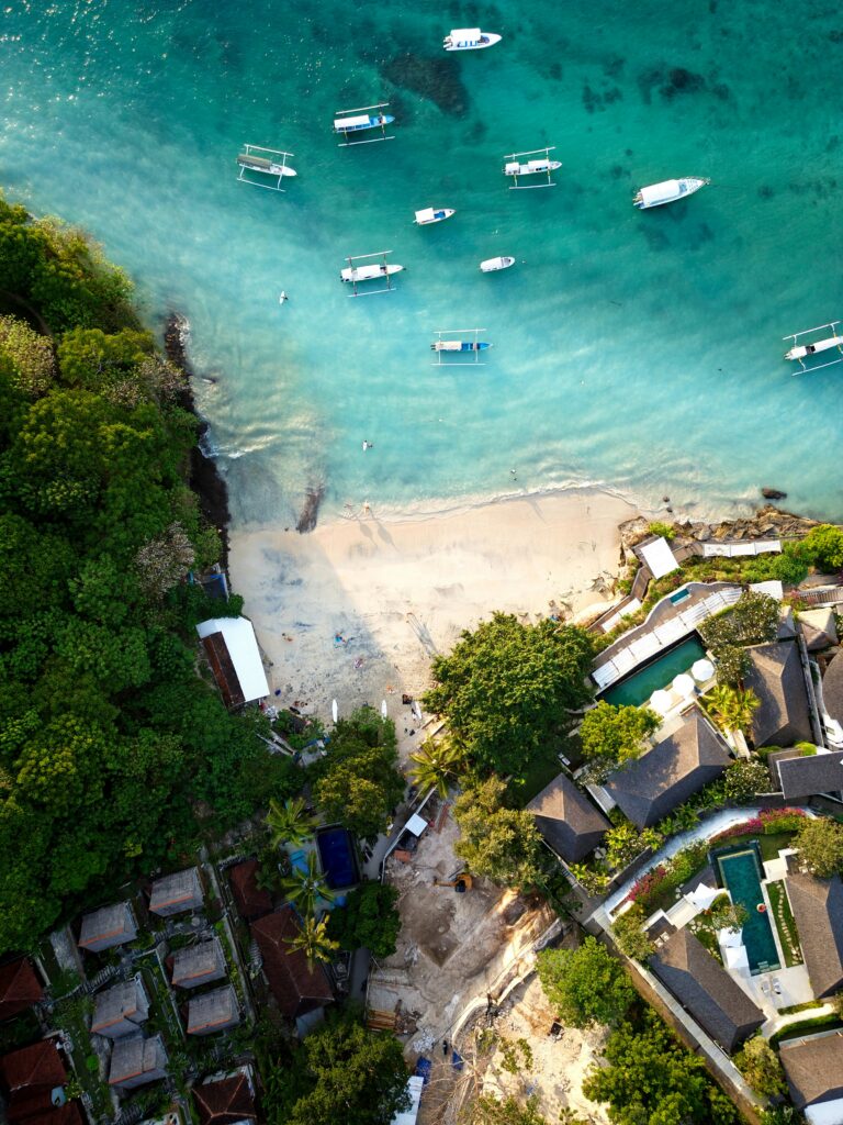 luchtfoto strand, zee met bootjes en huisjes Bali